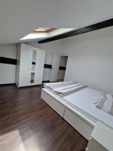 ein großes weißes Zimmer mit einem Bett und Holzböden in der Unterkunft 3 cosy bedrooms shared house with 4 beds near Paris in Deuil-la-Barre + 2 Fotos