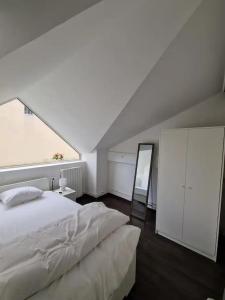 ein Schlafzimmer mit einem weißen Bett und einem großen Fenster in der Unterkunft 3 cosy bedrooms shared house with 4 beds near Paris in Deuil-la-Barre