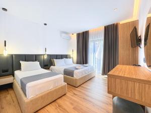 a hotel room with two beds and a flat screen tv at Zace Studios in Ksamil