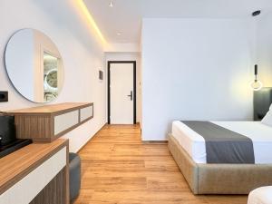 a hotel room with a bed and a mirror at Zace Studios in Ksamil
