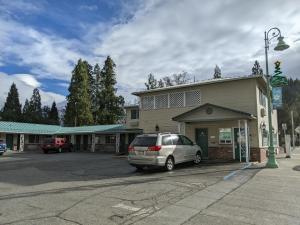 a car parked in a parking lot in front of a building at Hi-Lo Motel, Cafe and RV Park Mount Shasta Area in Weed