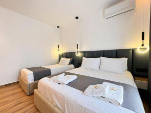 two beds in a hotel room with lights at Zace Studios in Ksamil