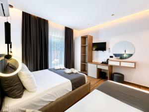 a hotel room with two beds and a mirror at Zace Studios in Ksamil