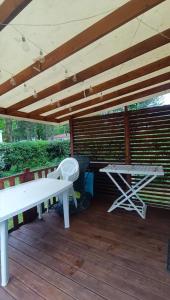 a white bench and a table on a wooden deck at Mobil home 2ch 5pers Tout Confort 25min PuyduFOU 710EM in La Boissière-de-Montaigu