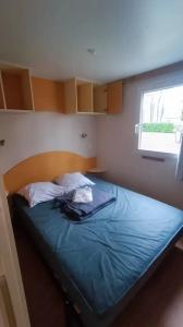 a bed in a small room with a window at Mobil home 2ch 5pers Tout Confort 25min PuyduFOU 710EM in La Boissière-de-Montaigu