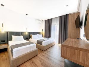 a hotel room with two beds and a television at Zace Studios in Ksamil