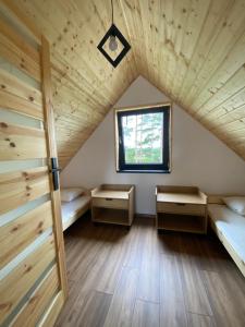 a room with two beds and a window at Kaszuby Sominy Domki Na Wczasowej in Sominy