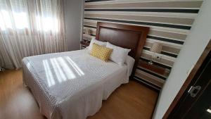 sypialnia z łóżkiem z żółtą poduszką w obiekcie Apartamento AGRELO w mieście Bueu