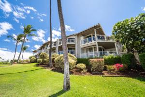 an exterior view of a house with palm trees at Grand Champions Golf Villas 150 in Wailea