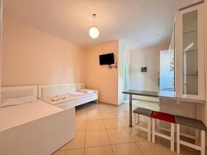 a room with a bed and a table and a desk at Zace Studios in Ksamil