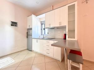 a large kitchen with white cabinets and a table at Zace Studios in Ksamil