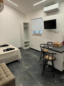 a room with a bed and a table and a tv at Suite Aurora in Crotone