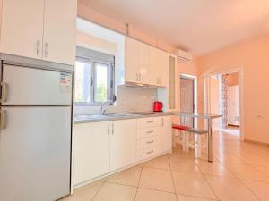 a kitchen with white cabinets and a refrigerator at Zace Studios in Ksamil