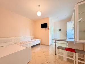 a room with a bed and a desk and a television at Zace Studios in Ksamil