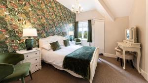 a bedroom with a king sized bed with a floral wallpaper at Roomours Hotel with Private Car Park in Llandudno