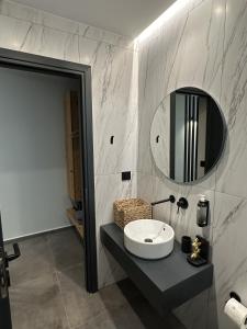 a bathroom with a sink and a mirror at Nusa retreat - Residences - Garden & Sea view in Kissamos