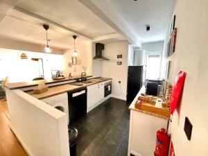 eine Küche mit weißen Schränken und einem schwarzen Kühlschrank in der Unterkunft Apartamento Marcajada in Riaza + 36 Fotos