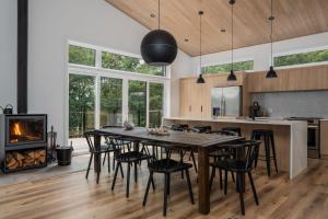 a kitchen and dining room with a table and chairs and a fireplace at Chalet Elva Nature & SPA in Sainte Béatrix