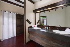 a bathroom with two sinks and a large mirror at Keyonna Beach - All Inclusive - Couples Only in Saint Johnʼs +44 photos