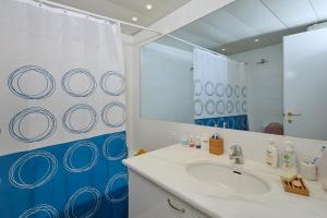 a bathroom with a sink and a mirror at soft blue apartment near seaside in Porto Rafti +12 photos