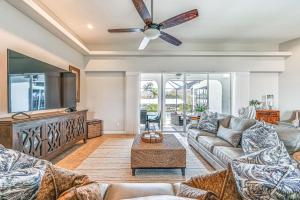 a living room with a couch and a ceiling fan at Marco Island Home with Screened Pool Less Than 1 Mi to Beach in Marco Island