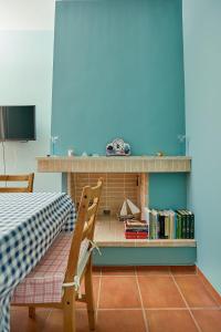 a room with a table and a chair and a shelf with books at soft blue apartment near seaside in Porto Rafti