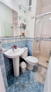 a bathroom with a toilet and a sink and a shower at Habitación en casa de Luis con espacios compartidos in Lima