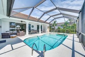 an indoor swimming pool in a house with a large window at Marco Island Home with Screened Pool Less Than 1 Mi to Beach in Marco Island