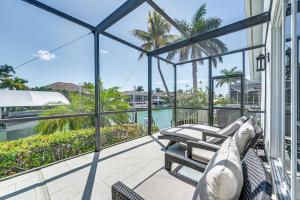 a balcony with chairs and a view of the water at Marco Island Home with Screened Pool Less Than 1 Mi to Beach in Marco Island