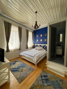 a bedroom with a bed and a blue wall at Konak Bergama in Bergama