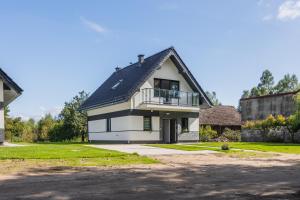 a white house with a black roof at Łasko - Wildlife Phototherapy - 4 luksusowe, klimatyzowane wille, z dostępem do oddalonego o 5 min spacerem prywatnego terenu rekreacyjnego in Bierzwnik