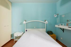 a blue bedroom with a white bed and a blue wall at soft blue apartment near seaside in Porto Rafti