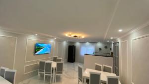a room with tables and chairs and a television on a wall at Edelweiss in Lazeshchyna
