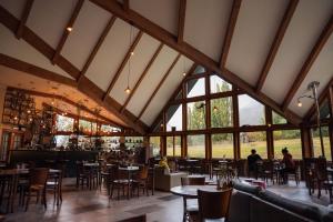 a dining room with tables and chairs and windows at Hotel Las Torres Patagonia in Torres del Paine