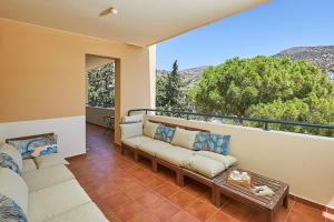a living room with couches and a balcony with a view at soft blue apartment near seaside in Porto Rafti
