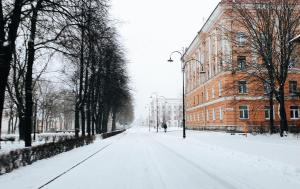 a snow covered street in front of a building at Keskallee Apartment in Kohtla-Järve