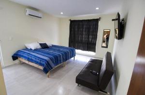 a bedroom with a bed and a flat screen tv at Casa vacacional con alberca in Antón Lizardo