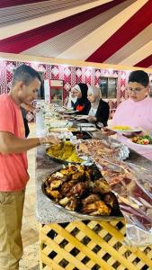a man standing in front of a buffet of food at Wadi Rum The ARC camp in Wadi Rum