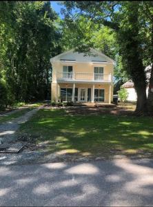 a large yellow house with a tree in front of it at Cozy Virginia Beach Vacation Home in Virginia Beach