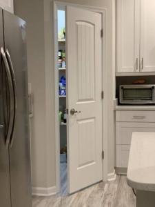 a kitchen with a white door and a refrigerator at Cozy Virginia Beach Vacation Home in Virginia Beach