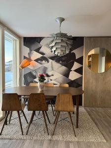 a dining room with a table and chairs and a mural at EnUtsiktBalsfjord in Storsteinnes