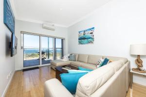 a living room with a couch and a table at Ocean Sunset - Luxury Apartment with Ocean Views in Lancelin