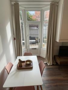 a dining room with a white table and chairs and a window at Flat 2, 297 Gillott Road, B16 0RT in Birmingham
