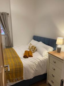 a bed with a blue headboard and two brown towels on it at Flat 2, 297 Gillott Road, B16 0RT in Birmingham