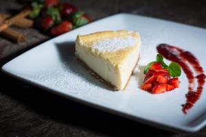a piece of cheesecake with strawberries on a white plate at Zoola hotel San Pedro La Laguna in San Pedro La Laguna