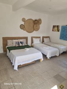 una camera con due letti e un orsacchiotto sul muro di Pousada Lua de Jeri a Jericoacoara