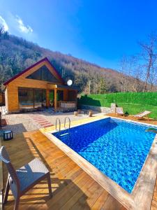 a swimming pool in front of a house at İstanbuldere Bungalov in Sapanca