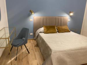 a bedroom with a bed and a chair at La Zisa Luxury Apartment in Palermo