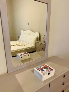 a mirror on a dresser with a bed in a bedroom at Porto Levante Anemos in Ermoupoli