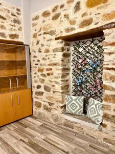 a room with a stone wall with a wine rack at Porto Levante Anemos in Ermoupoli +7 photos